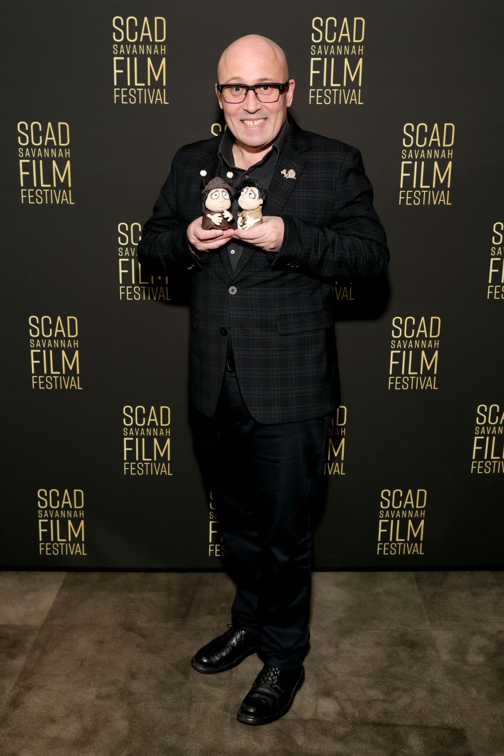 a man holds two figurines