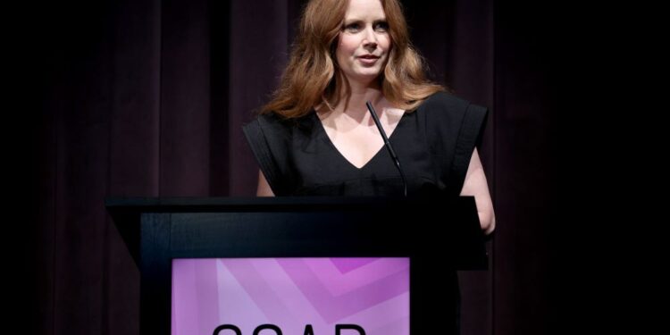 a woman talks at a podium