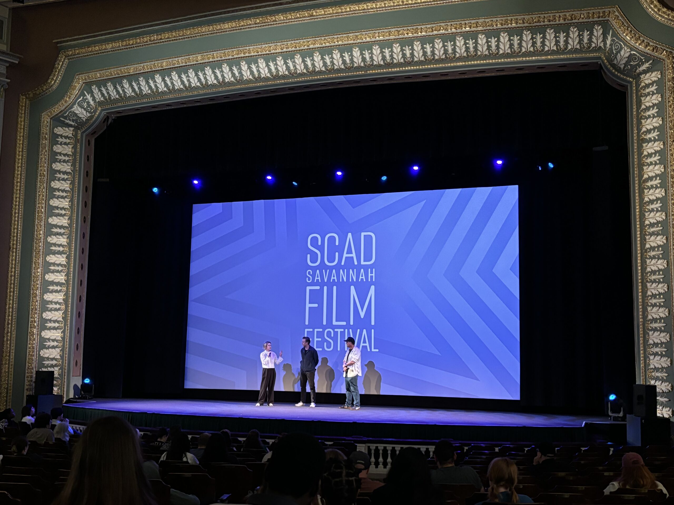 three people on stage in the Lucas Theater