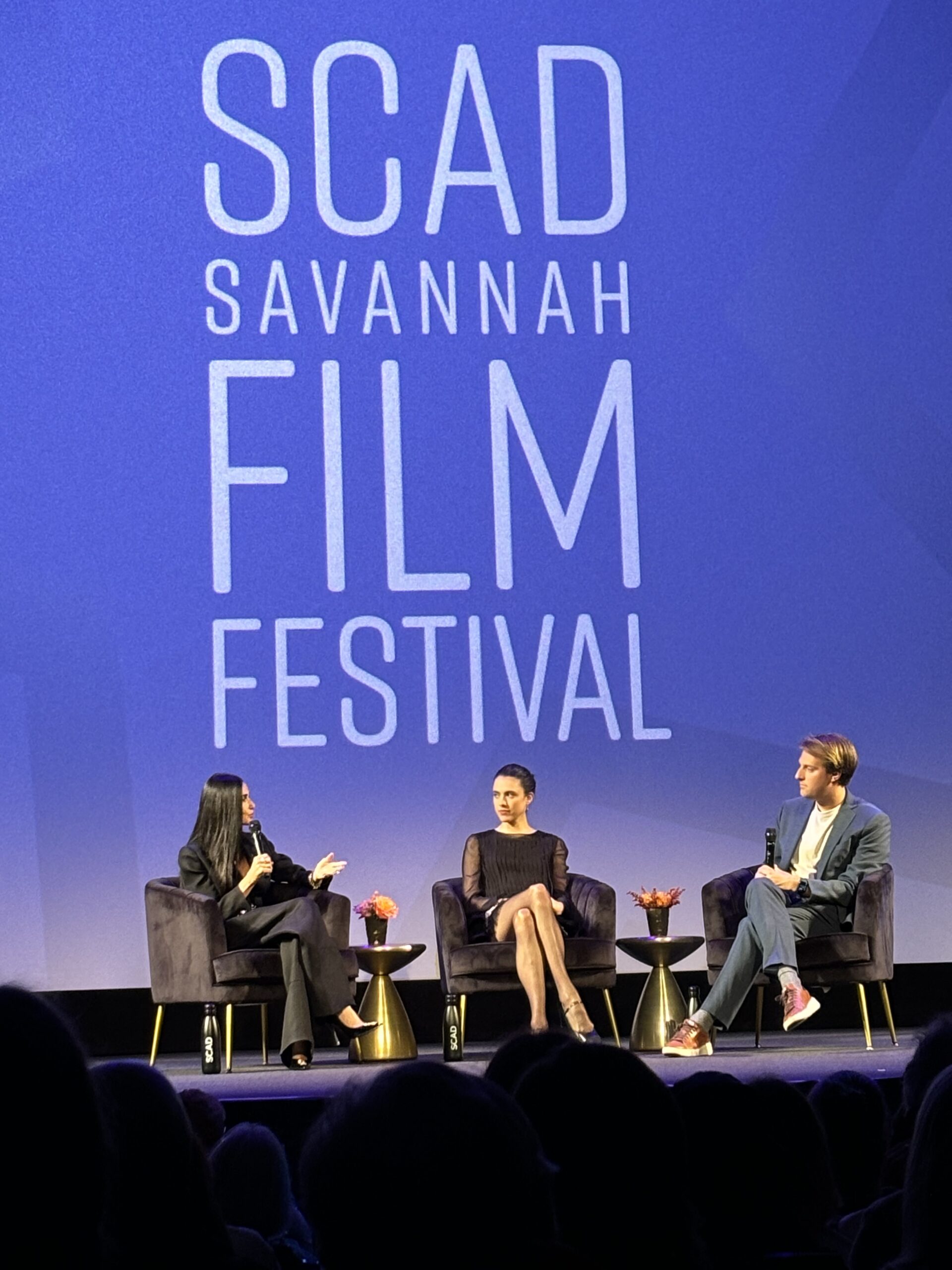 three people on stage with a blue background that reads SCAD Savannah Film Festival