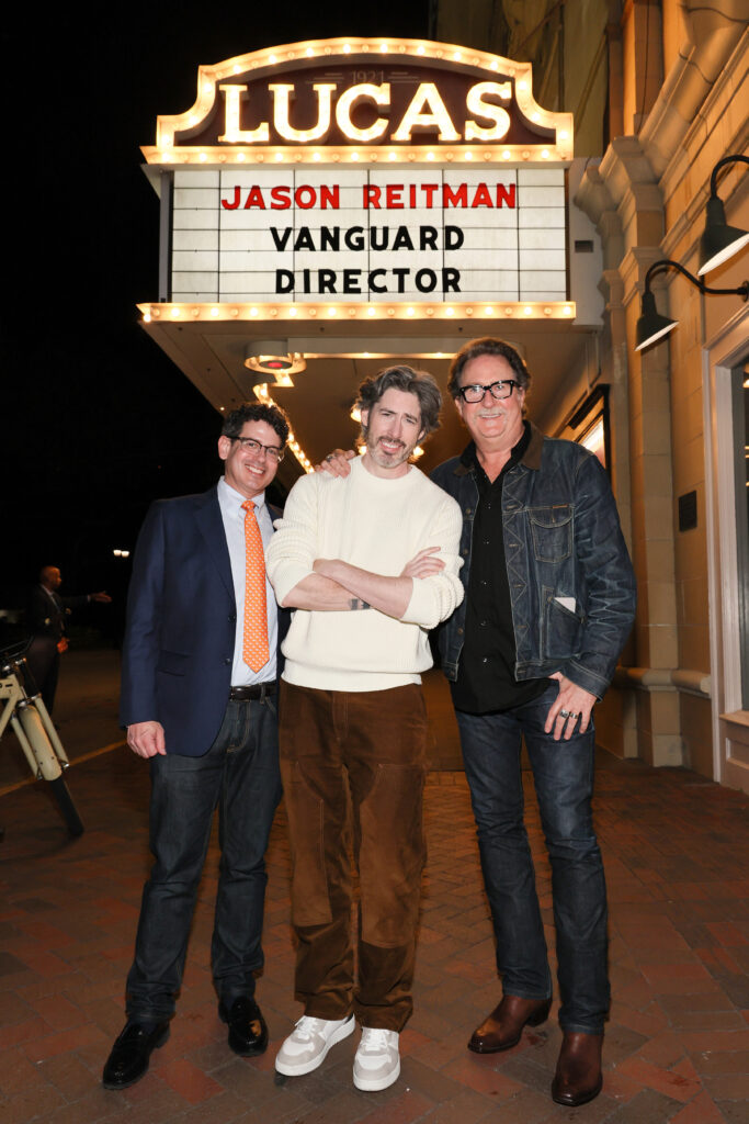 three men outside a theater marquee that says Jason Reitman Vanguard Director