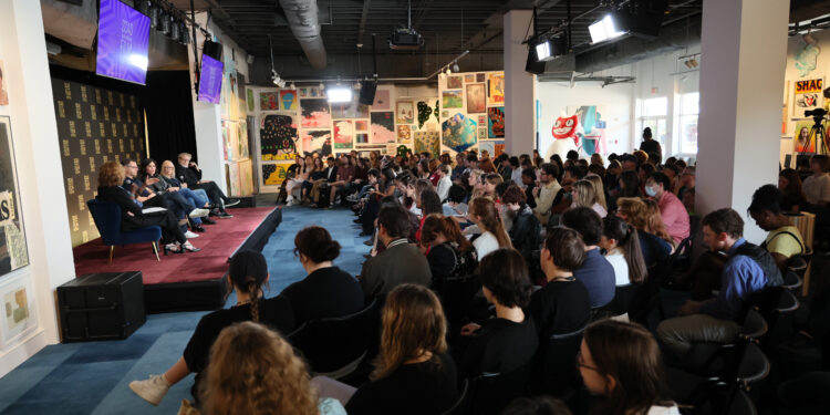 a group of people in a gallery with people on stage
