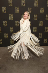 woman twirling in a fringe dress on the red carpet