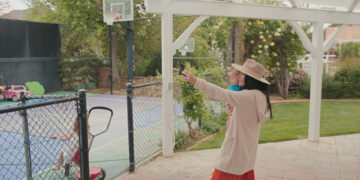 a woman holding a child while taking a selfie in a backyard
