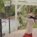 a woman holding a child while taking a selfie in a backyard