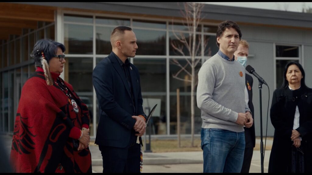 Justin Trudeau and others stand at a press conference for Indigenous people