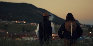 two men overlook a rural setting