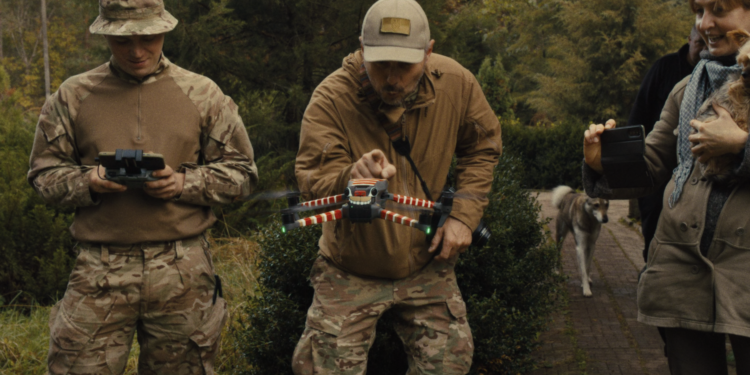 three men in army fatigues working a drone
