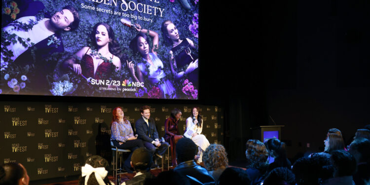 the cast of Gross Pointe Garden society stand in front of the show's image on stage