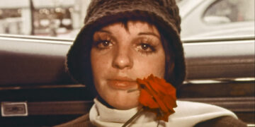 liza minnelli sitting in the backseat of a car holding a rose