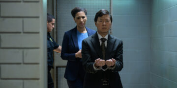 an asian man in handcuffs being brought into court