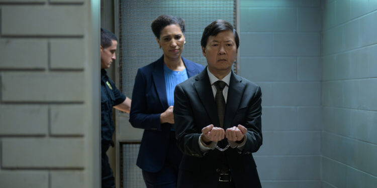 an asian man in handcuffs being brought into court