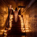 a woman walks up a stairway filled with candles