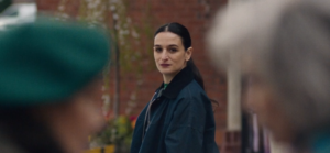 a woman watches two older women talking