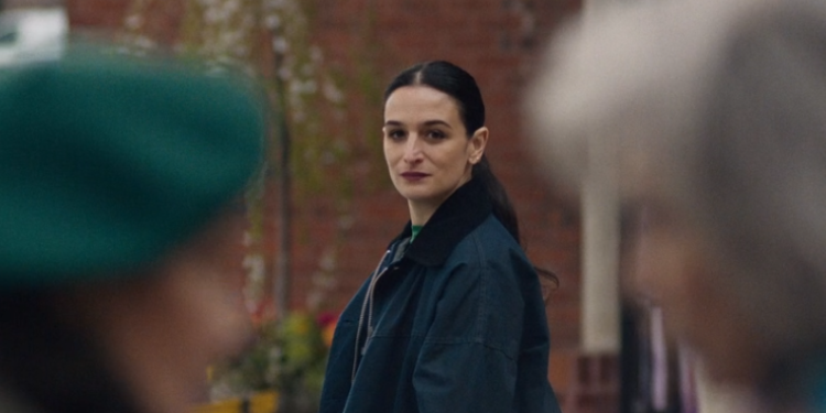 a woman watches two older women talking