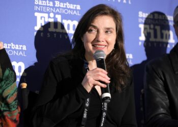 a woman with a microphone speaks at the santa barbara film festival