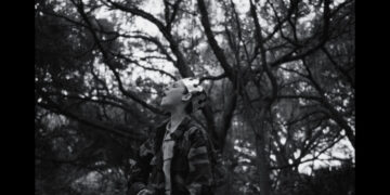 a boy wearing a crown screams in a forest