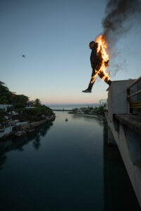 a man jumps off a bridge while his body is on fire