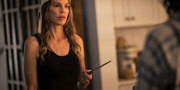 hilary swank holds a knife in a kitchen