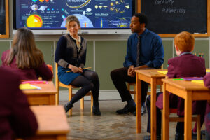 bridget jones and her love interest scott played by chiwetel ejiofor sit in front of a classroom