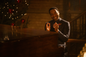 Chiwetel Ejiofor applauds by a piano in Bridget Jones Mad About the Boy