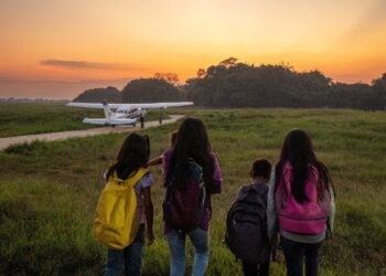 four children walking toward a plane