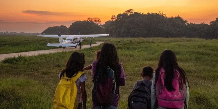 four children walking toward a plane