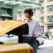 Dakota Johnson closes a cab trunk in Materialists