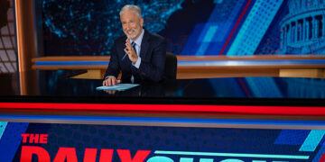 jon stewart at the desk of the daily show