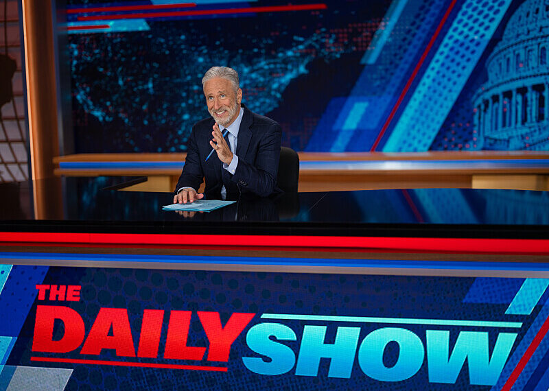 jon stewart at the desk of the daily show