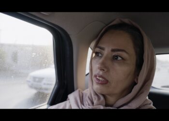 tehereh sits in the back of a taxi in iran in an eye for an eye documentary