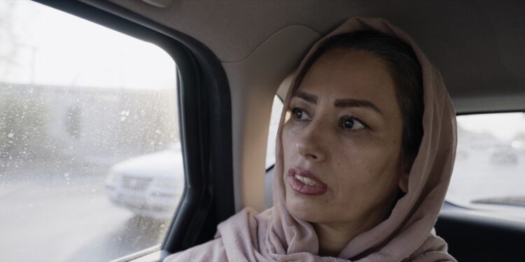 tehereh sits in the back of a taxi in iran in an eye for an eye documentary