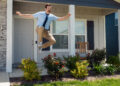 Ted lasso leaps in the air outside of a house