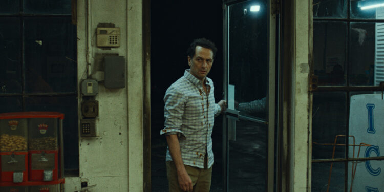 matthew rhys as tom loftis enters a convenience store on widow's bay