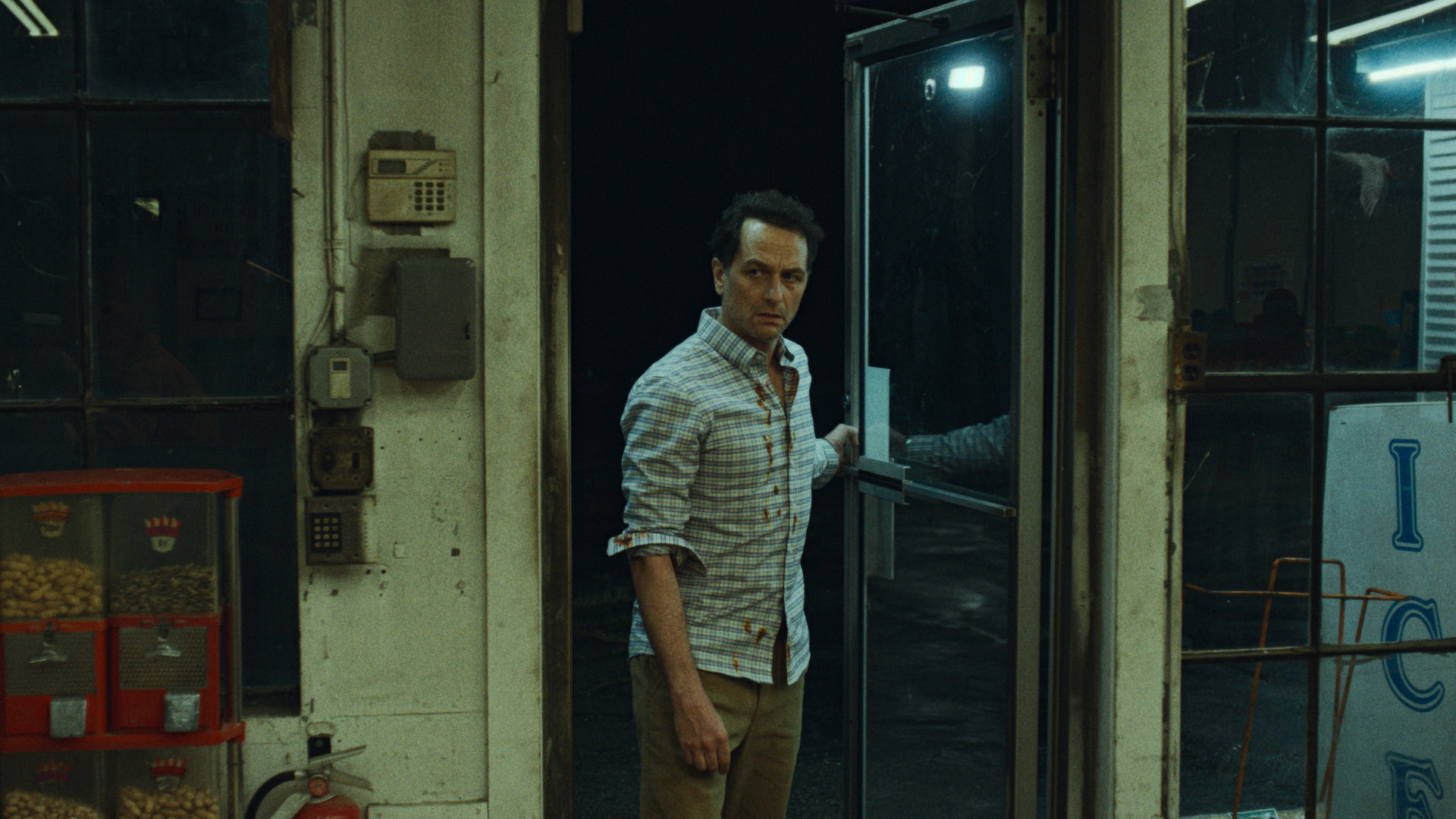 matthew rhys as tom loftis enters a convenience store on widow's bay
