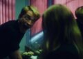 Primetime film still featuring Robert Pattinson making a face to someone in the bathroom