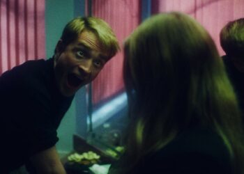 Primetime film still featuring Robert Pattinson making a face to someone in the bathroom